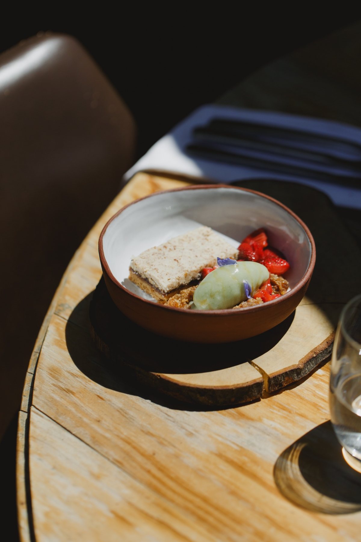 A plated dessert with cake, berries and a scoop of ice cream